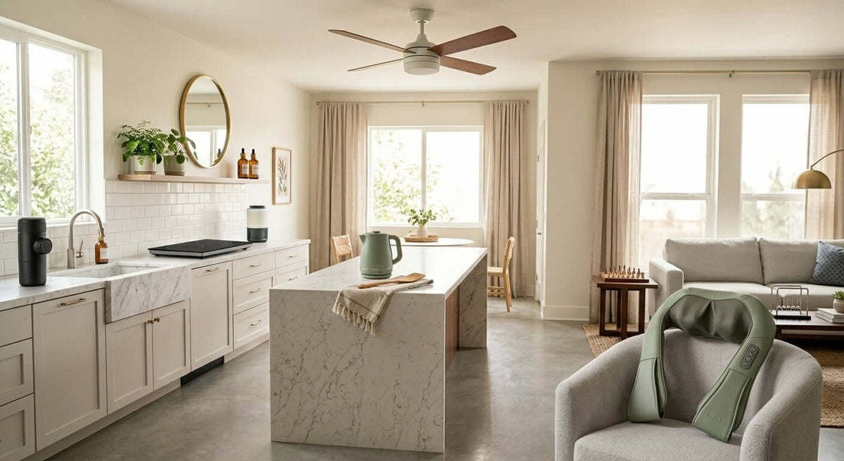 A modern, minimalist kitchen and living room featuring our best selling products,with natural light, featuring a marble kitchen island, massage neck pillow on an armchair, and neutral decor, illustrating comfortable, stylish home essentials.