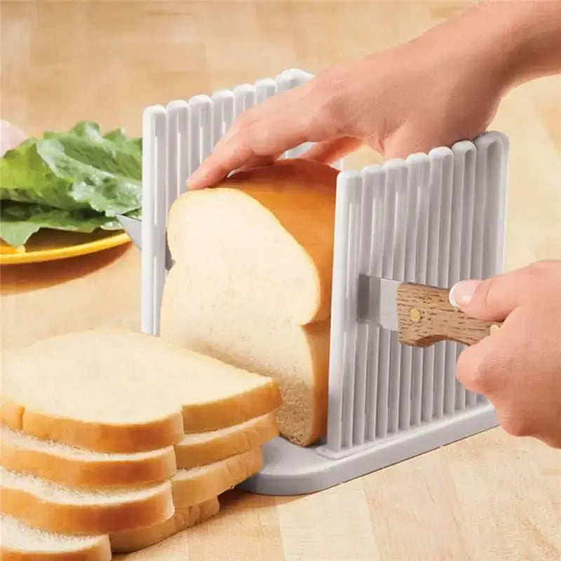 Foldable toast bread slicer with white ribbed plastic sides and wooden handle, slicing a loaf of bread into even pieces for breakfast.