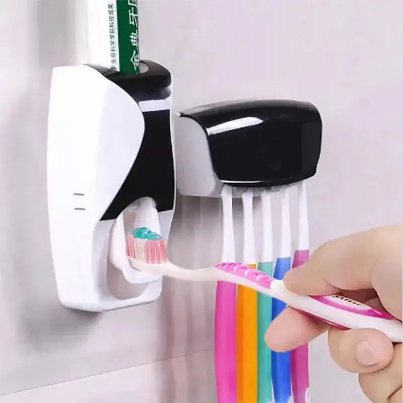 Automatic toothpaste dispenser with toothbrush holder mounted on bathroom wall, dispensing toothpaste onto a toothbrush, black and white design